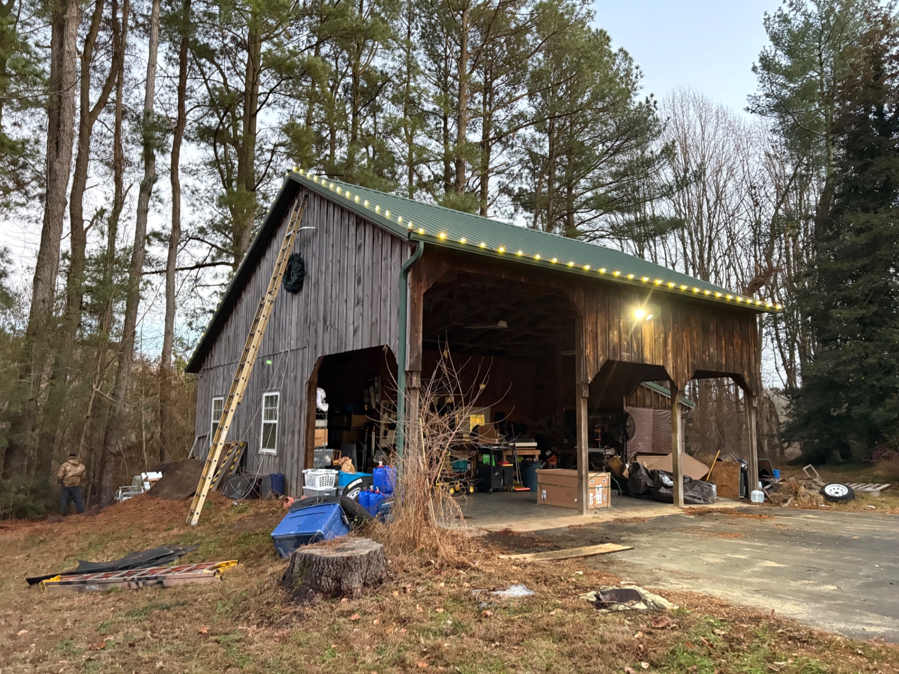 Warm white roofline lights on a rustic barn with a green metal roof